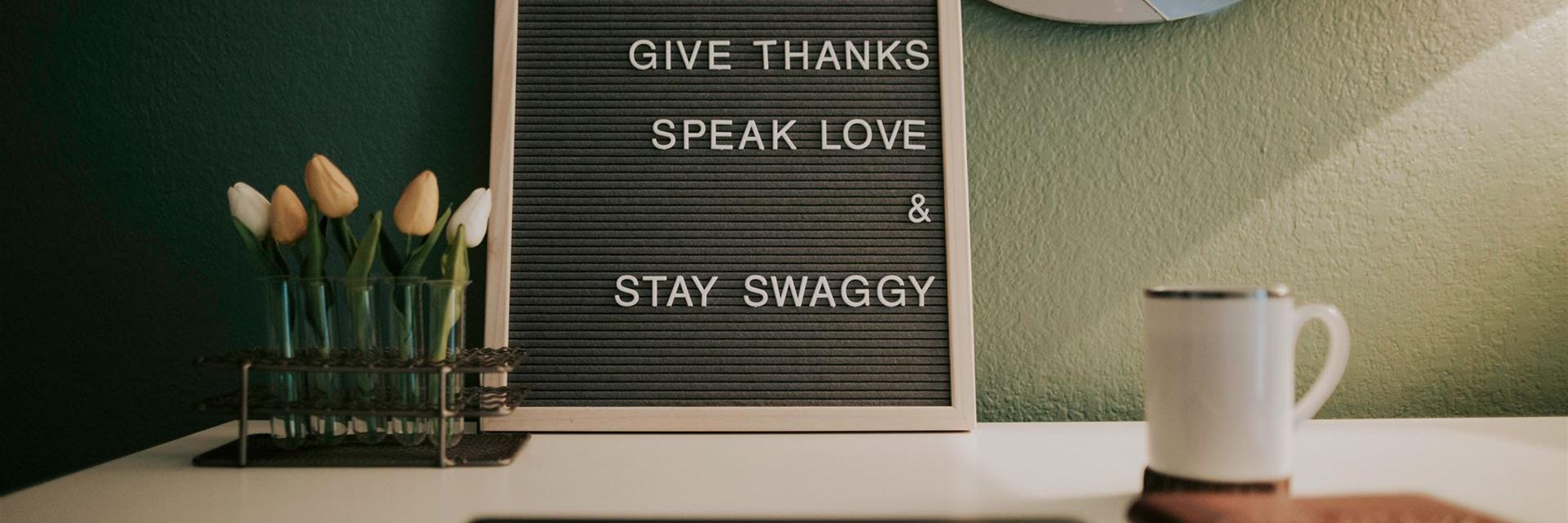 Rahren mit Texten auf Schreibtisch mit Tasse und Blumen