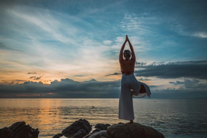 Yoga Pose Baum am Strand beim Sonnenuntergang